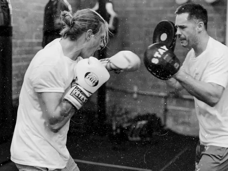 Boxtraining an den Pratzen: Schlag auf die Pratze des Trainers, schwarz-weiß